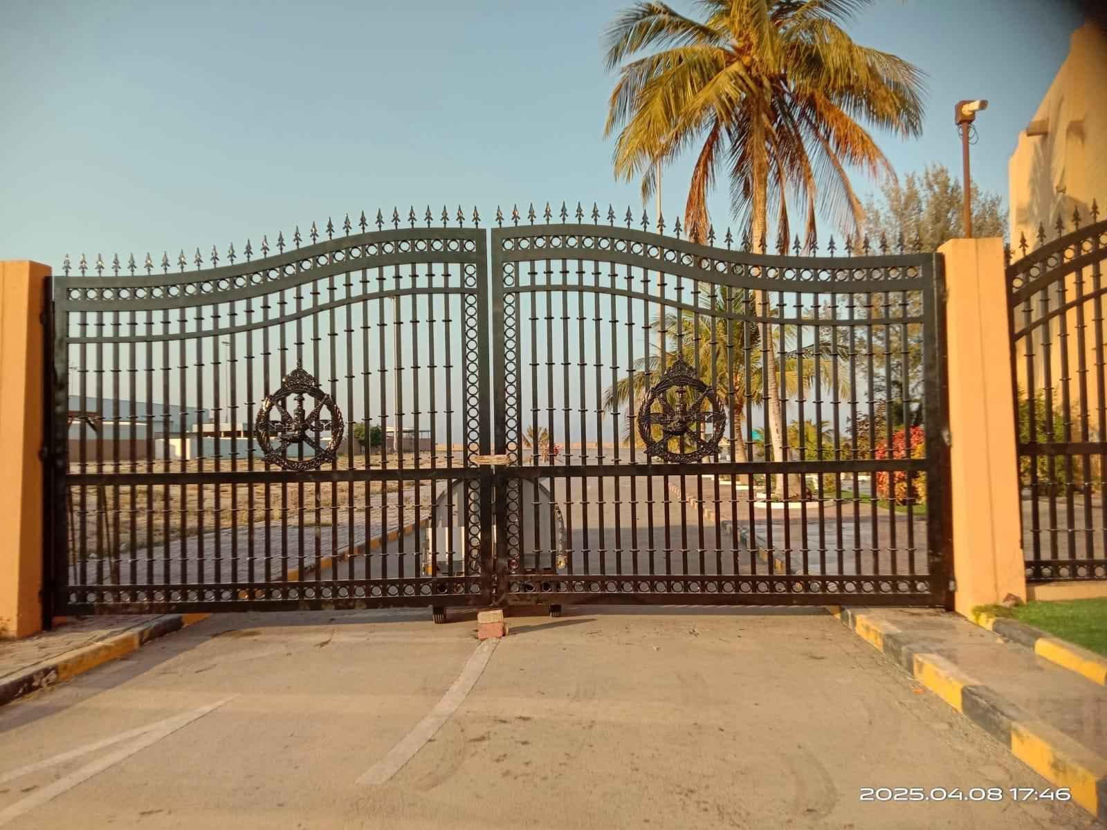 Completed automatic swing gate at a coastal villa in Oman, closed at dusk