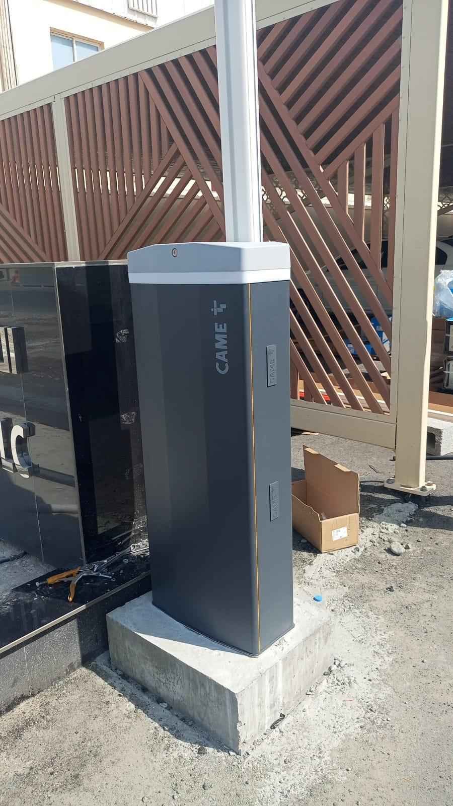CAME boom barrier on a concrete plinth at a commercial car park entrance in Oman