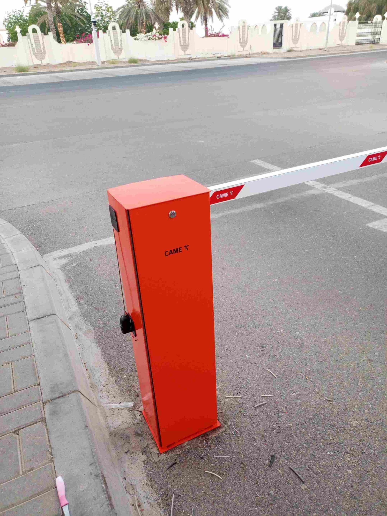 Red CAME boom barrier installed at a villa entrance in Oman