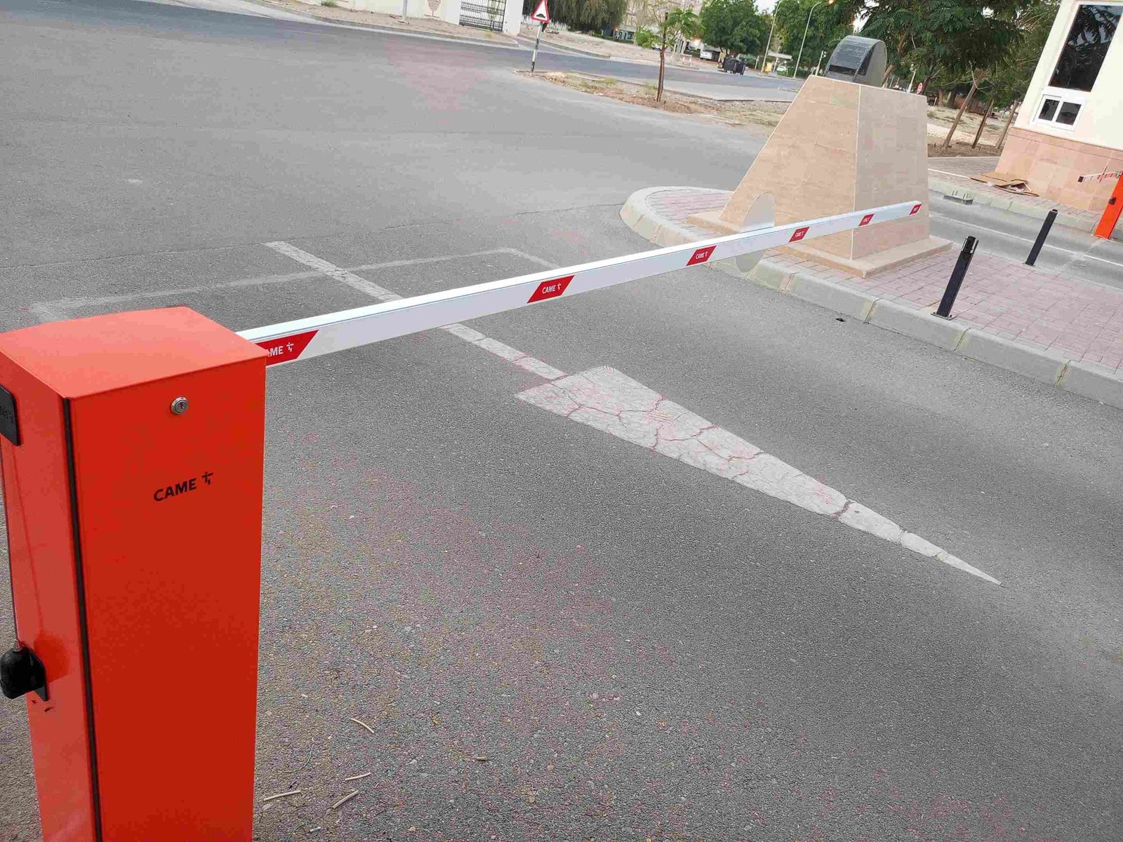 CAME parking barrier with the boom arm lowered across a residential road entrance in Oman