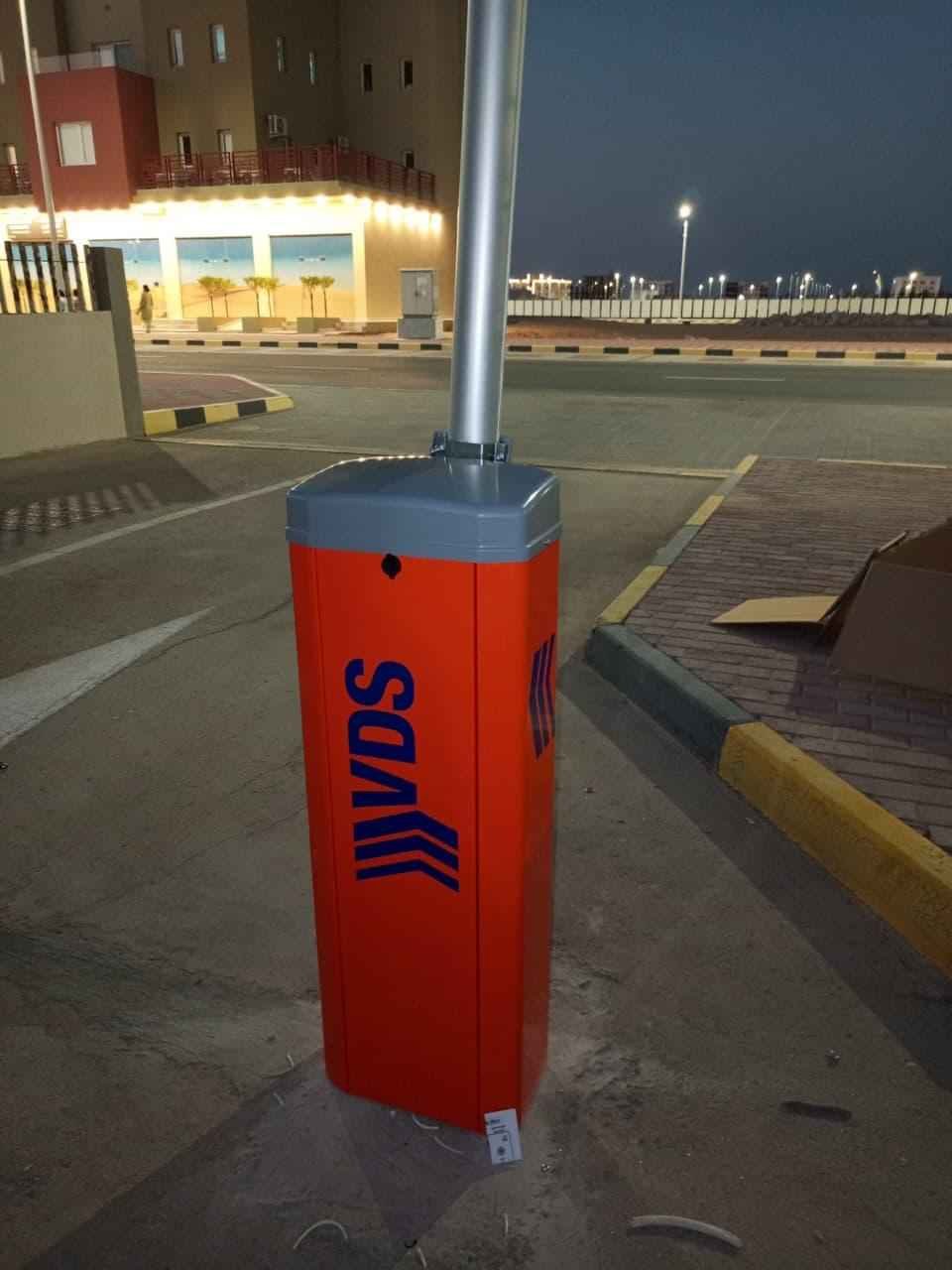 VDS boom barrier with the arm raised at a lit commercial entrance in Oman